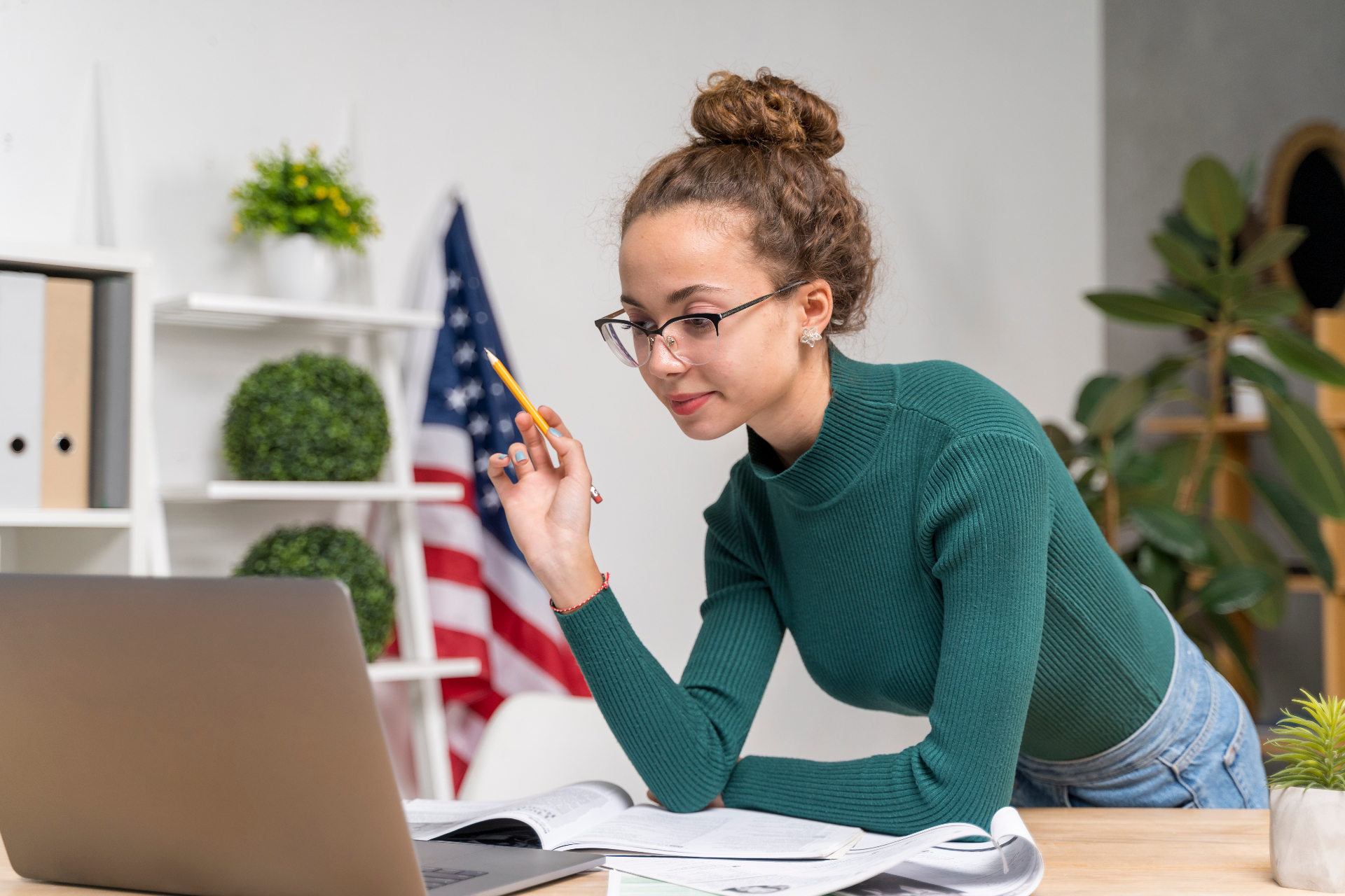 Aluna estudando inglês no notebook com bandeira americana